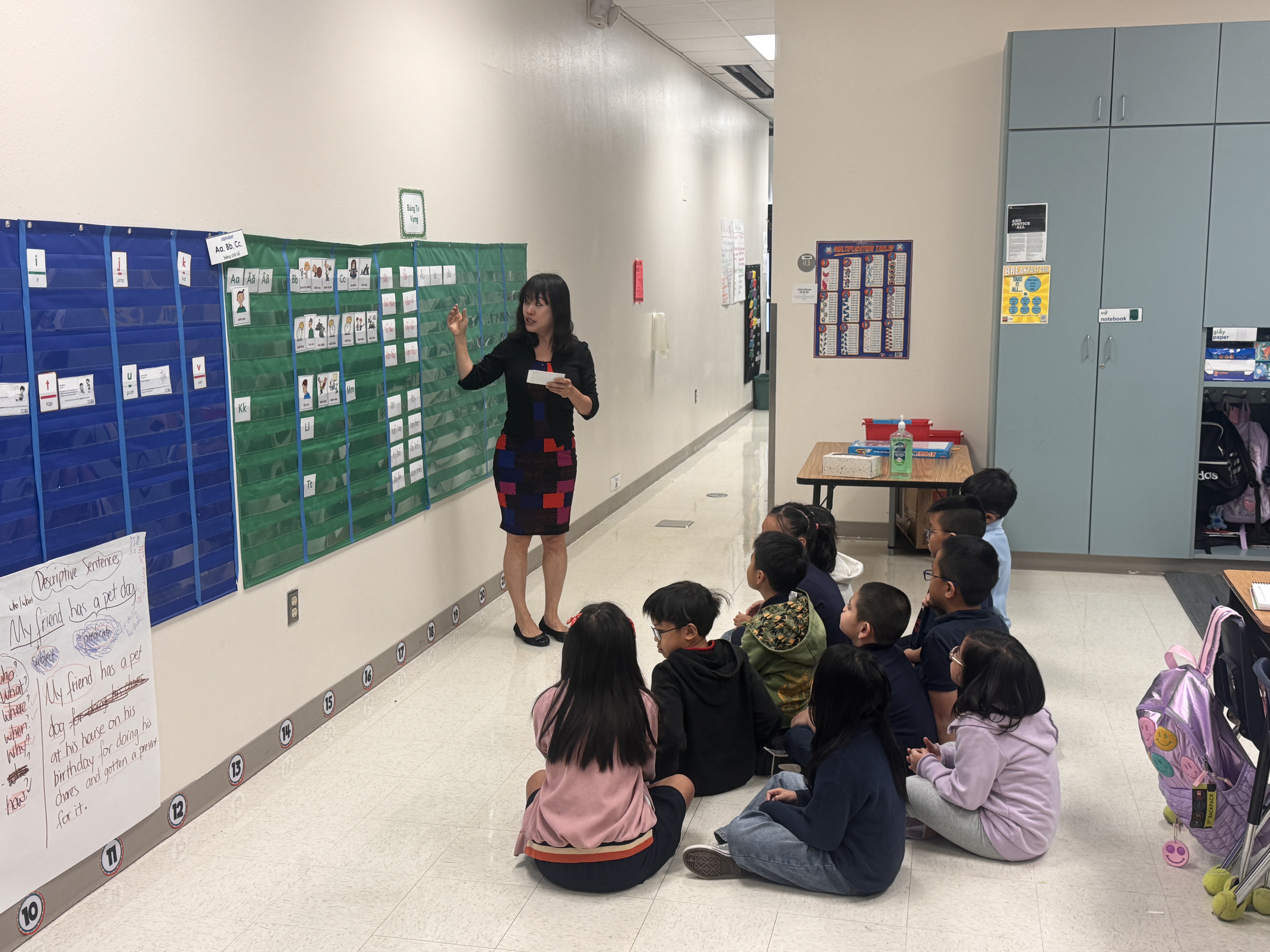 Teacher stands while teaching to a small group of seated students