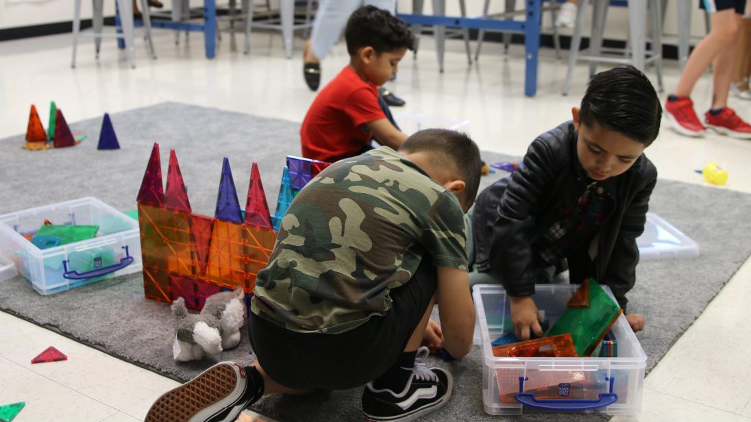 Three boys play with building toys
