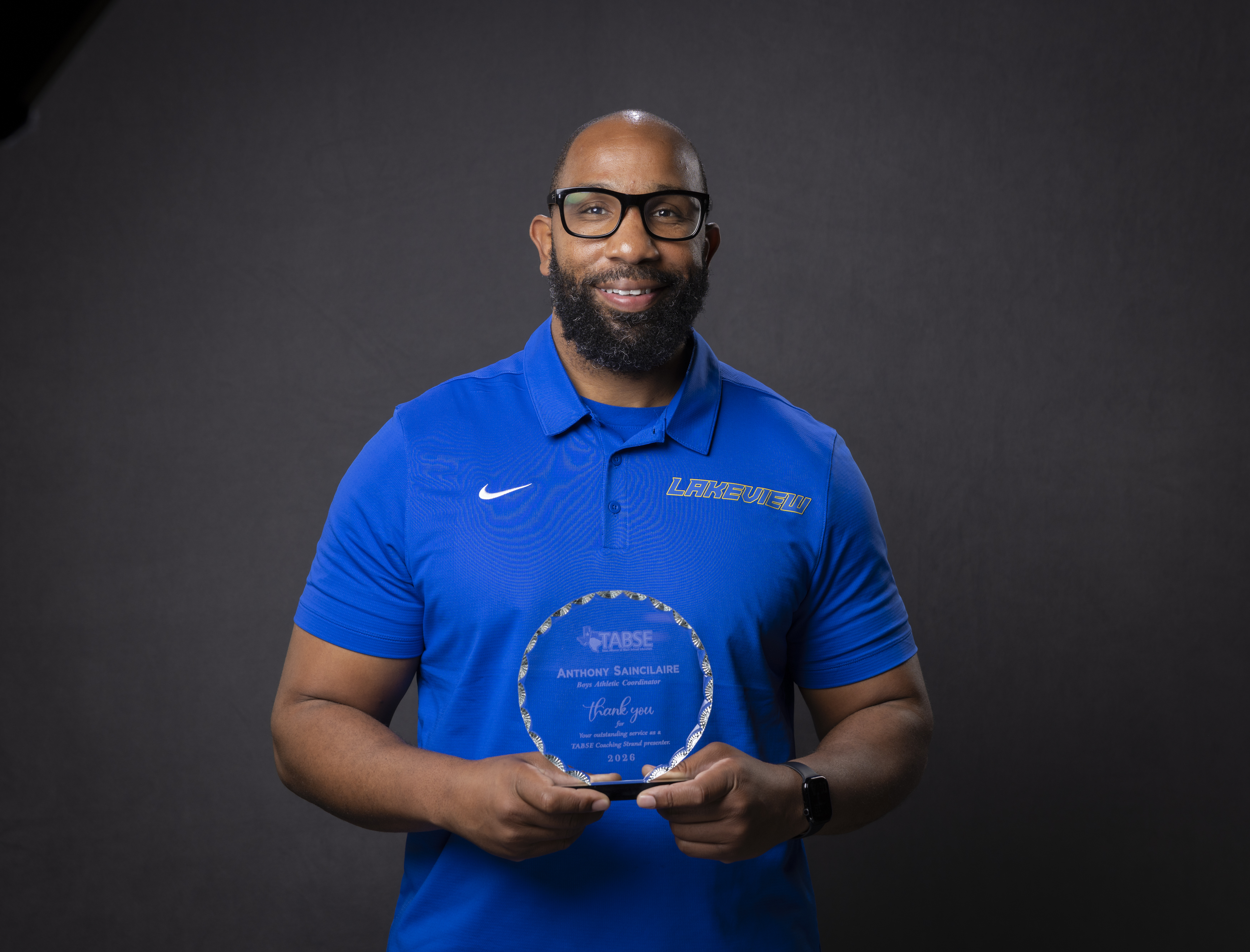 adult male stands with a crystal award