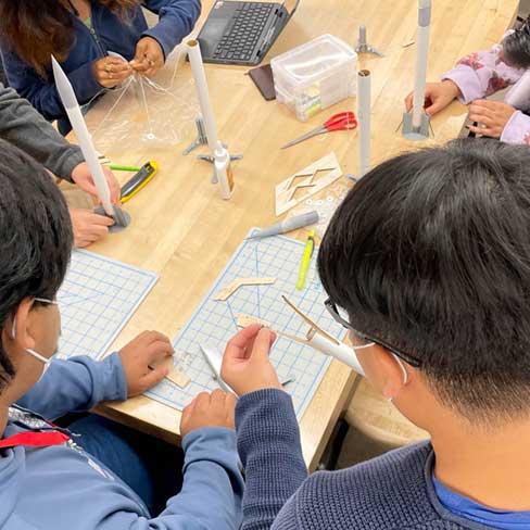 Students collaborating on plans for small rockets in MST class.