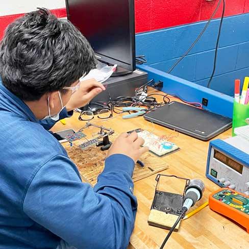 Student working with solder in P-TECH class at SGHS.