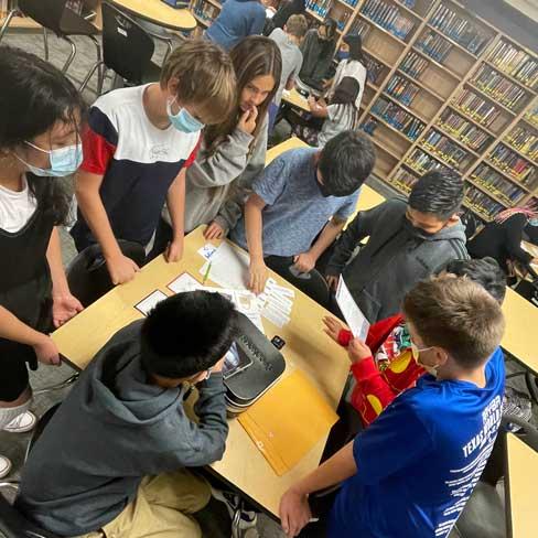 Group of students collaborating on a project in the library at Austin Academy for Excellence.