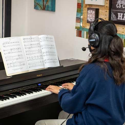 Girl playing piano in class at the Classical Center at Brandenburg.