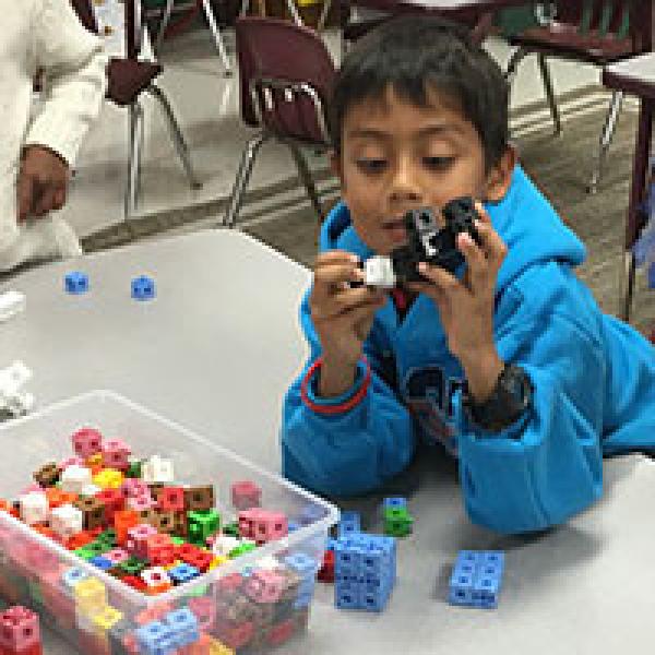 Student works on STEAM activity with blocks