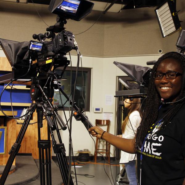 High school girl working video camera for LCHS's tv program.