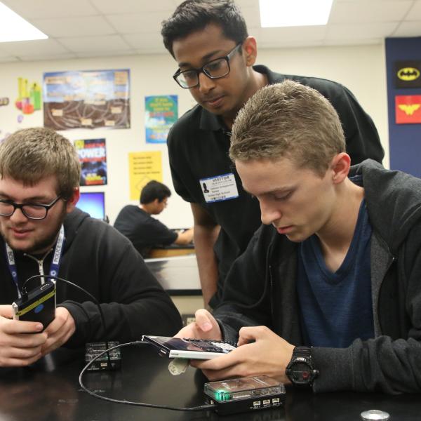 Boys collaborating during Collegiate Academy project.