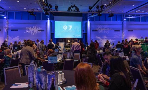 Tinsel & Trivia on screen in front of attendees at table