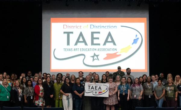GISD art educators stand in front of large sign