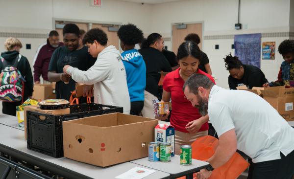 A group of students pack food into bags