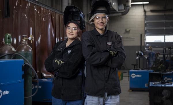 female and male welding students pose with their arms crossed