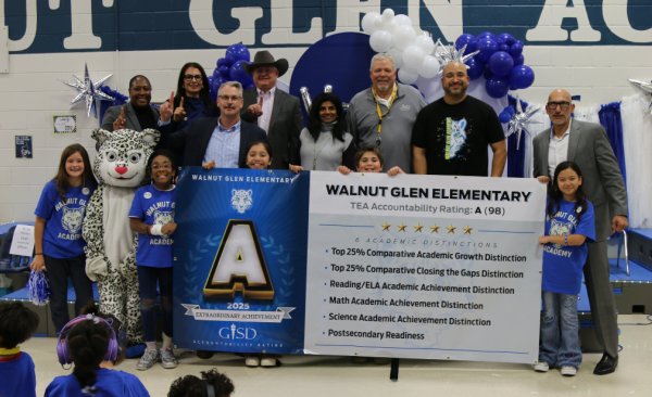 students and adults stand holding a large horizontal banner
