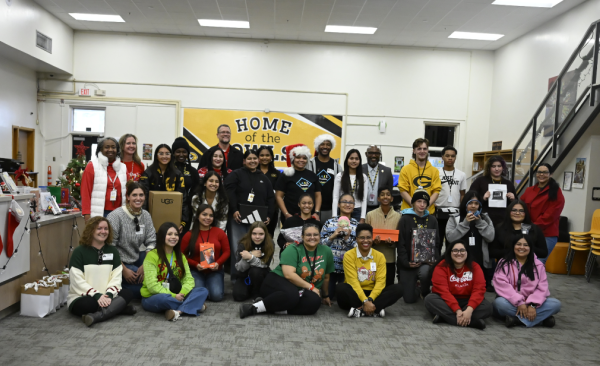 Students and staff pose for a photo with some people seated and some standing
