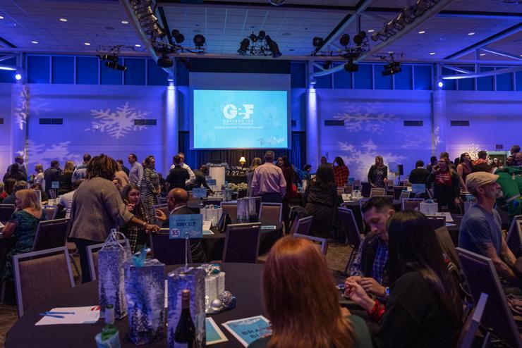 Tinsel & Trivia on screen in front of attendees at table