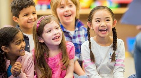 A smiling Asian-American student surrounded by other happy students.