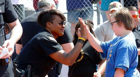 A School Resource Officer high-fiving a student at the Special Olympics.