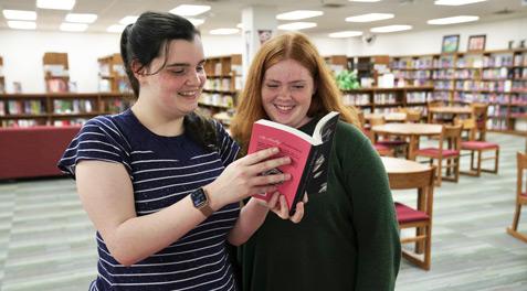 Two students look at the Faulty Endearment together in their school's library, a book published by a Garland ISD student.