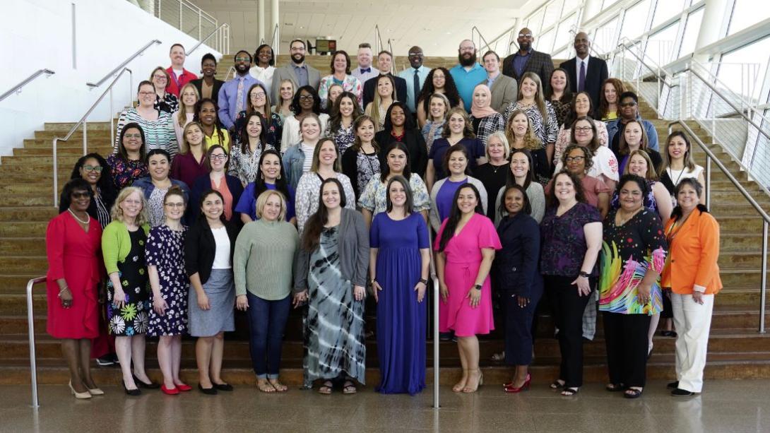 Garland ISD Teachers of the Year from all campuses standing on stairs at the Curtis Culwell Center