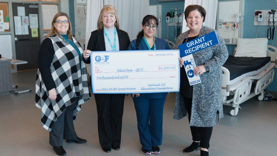 Medical CTE teachers show off their grant from GEF in the "surgery" classroom.