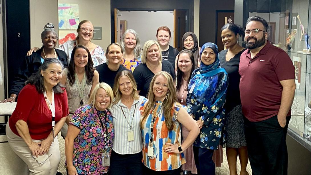 Several Garland ISD Dyslexia Therapists stand smiling in a hallway together.