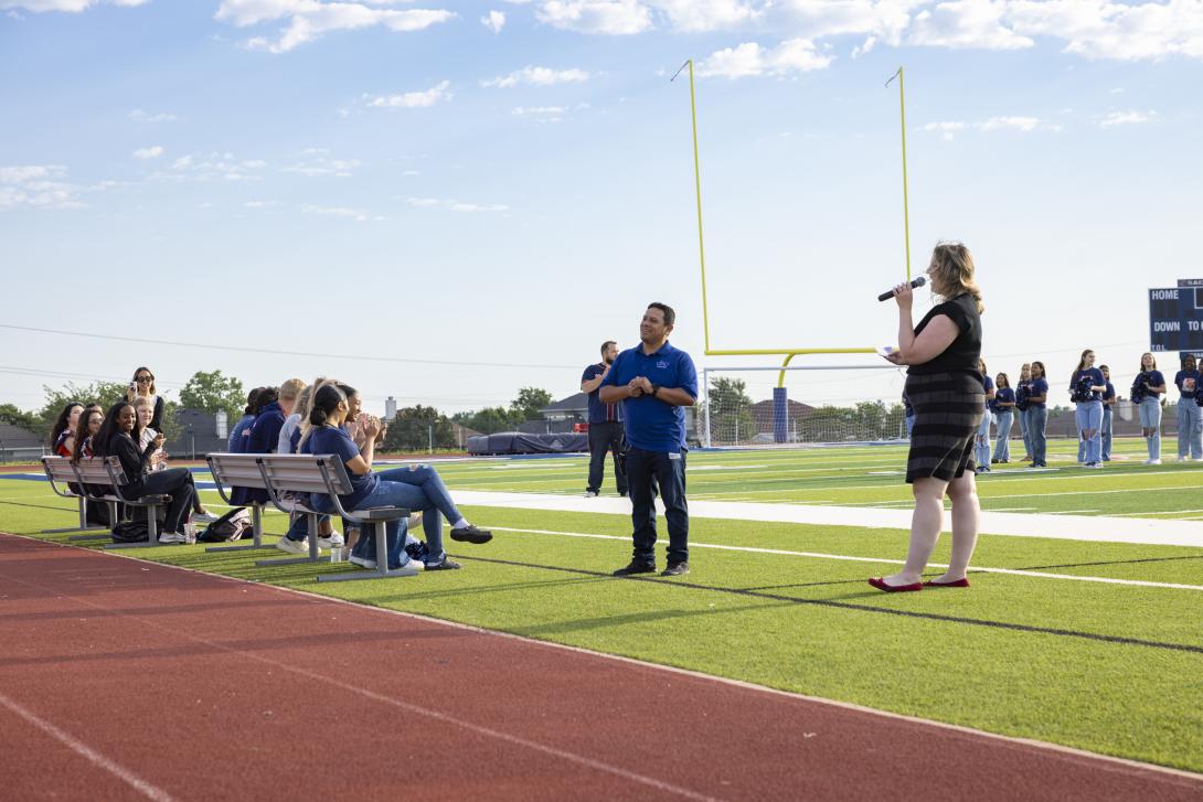 Woman with microphone addresses a man to her right