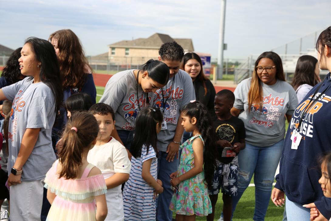Seniors and kindergarteners smile and hold hands