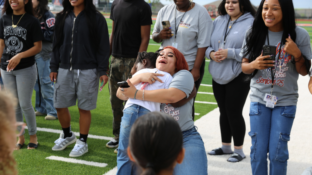 Two students hug