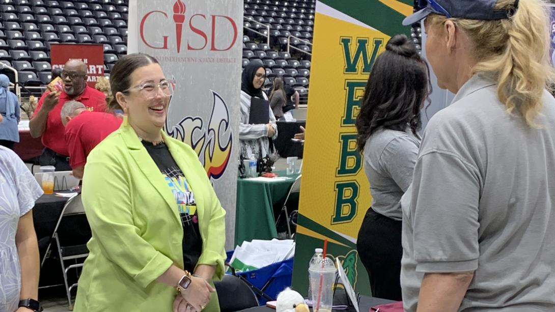 A staff member laughs while chatting with a candidate.