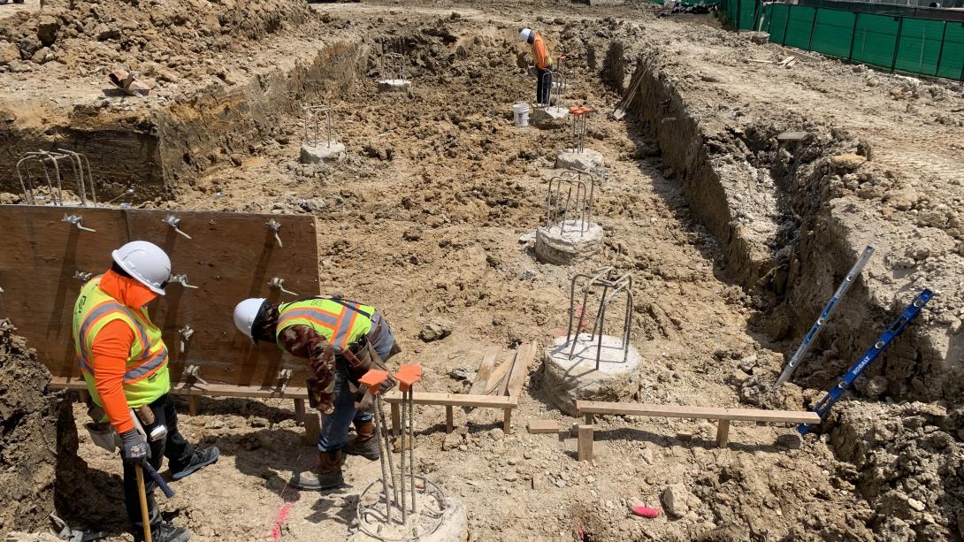 Two construction workers working in the ground