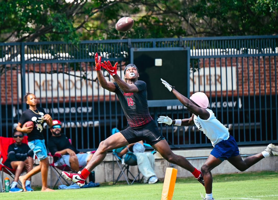 Football player looks up as he tries to catch the ball