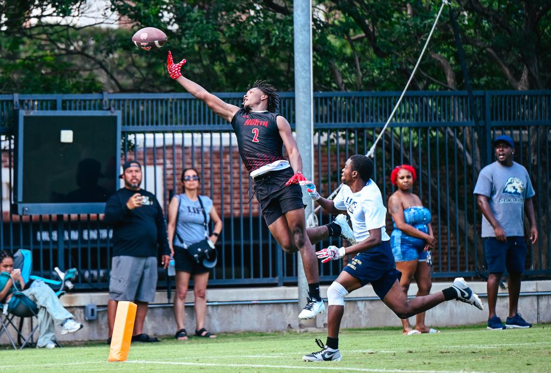 Football player jumps into the air to catch the ball