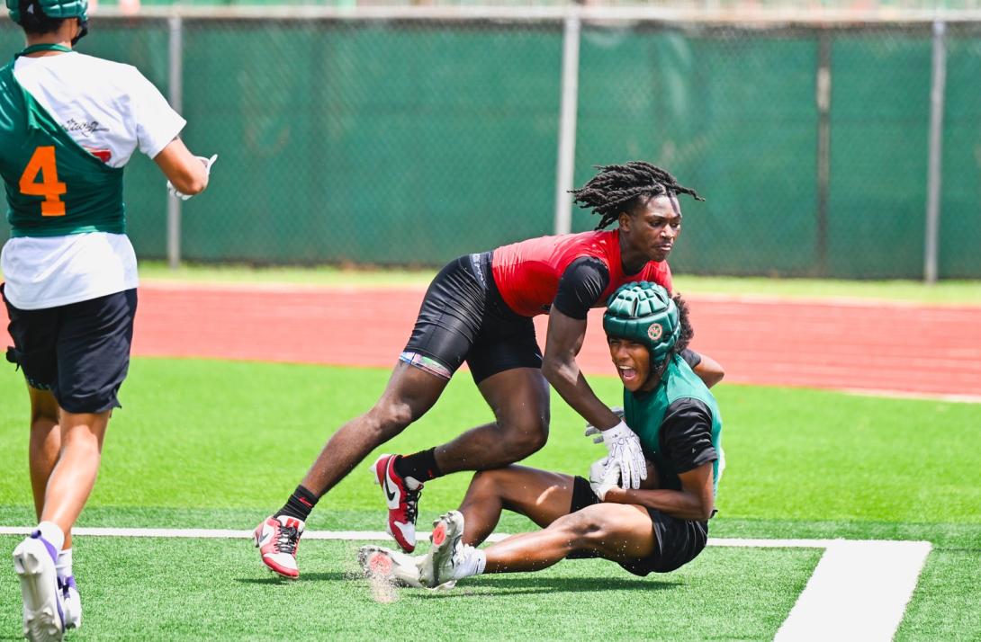 Football player falls to the ground after catching the ball