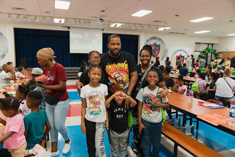 A family of five stands together smiling