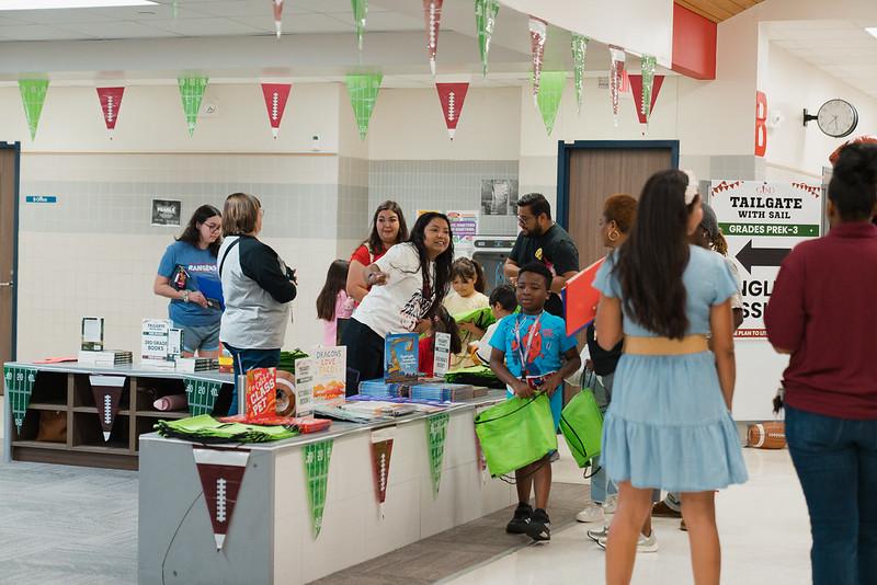 A woman behind a desk directs a family 