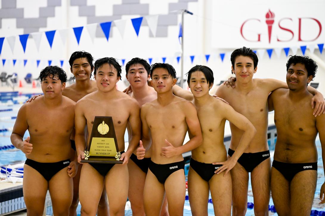 Boys water polo team poses with trophy