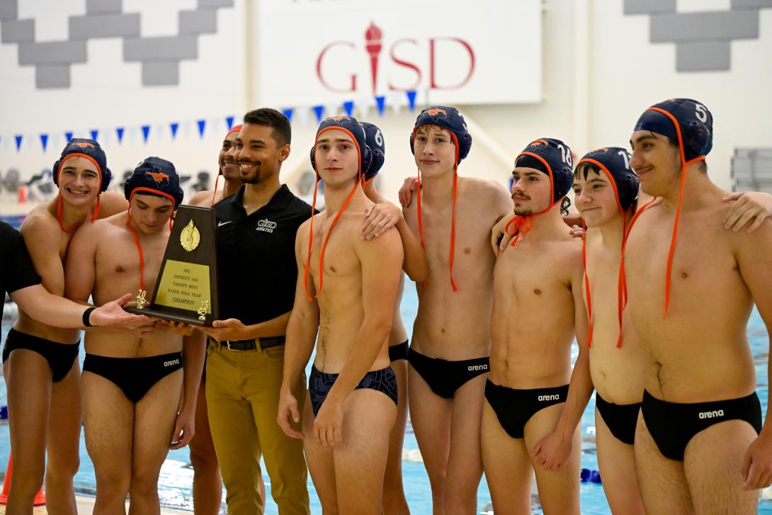 Boys water polo team and coach pose with trophy