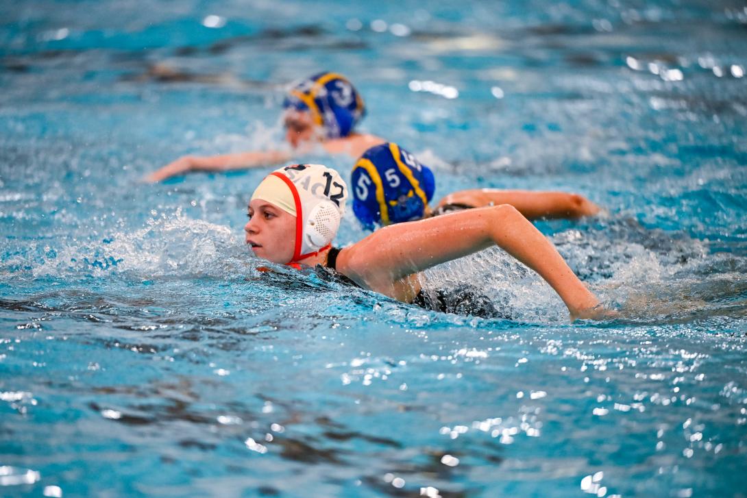 Water polo player swims in the water