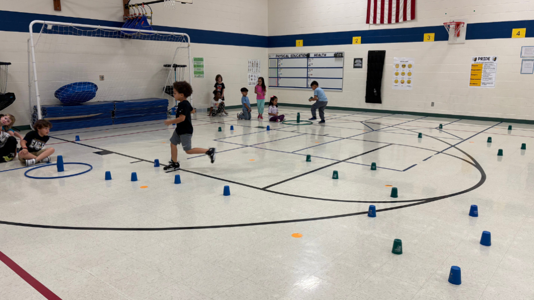 Students run around the gym 