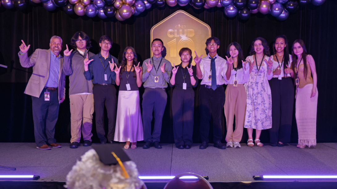 a diverse of group of students stand on the stage with their principal