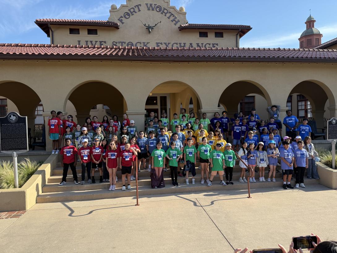 a large group of students stand in front of the Fort Worth Stockyards entrance
