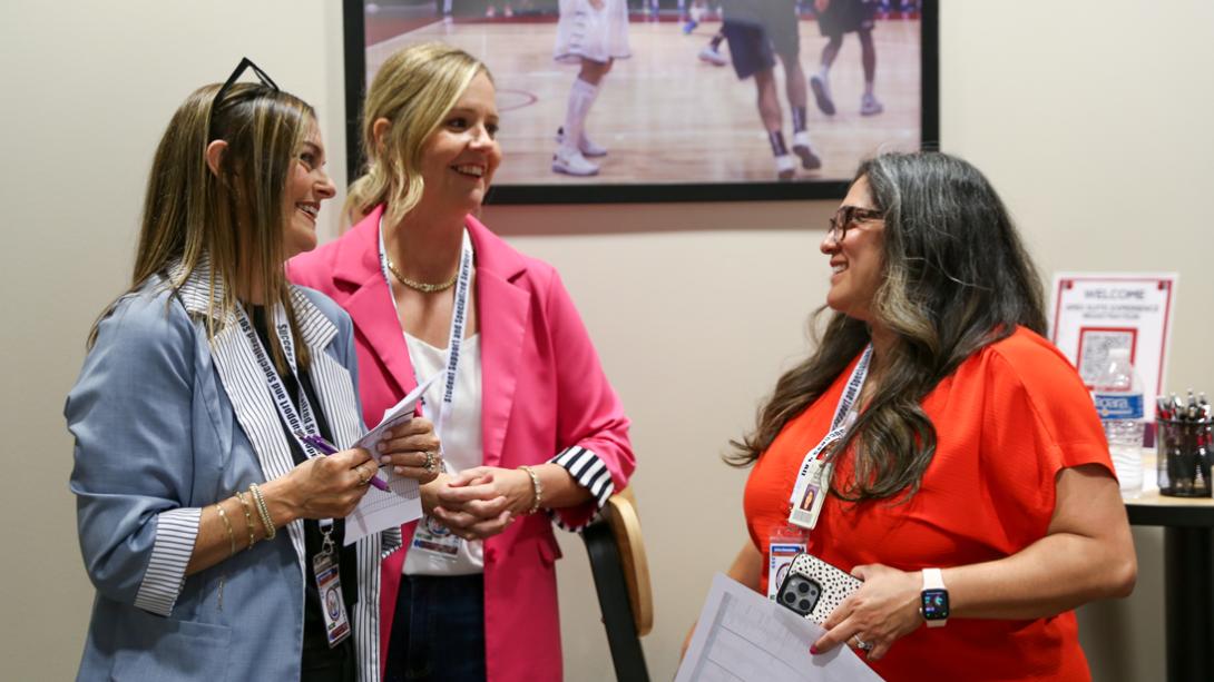 Three GISD Special Education staff laugh together while prepping for interviews.